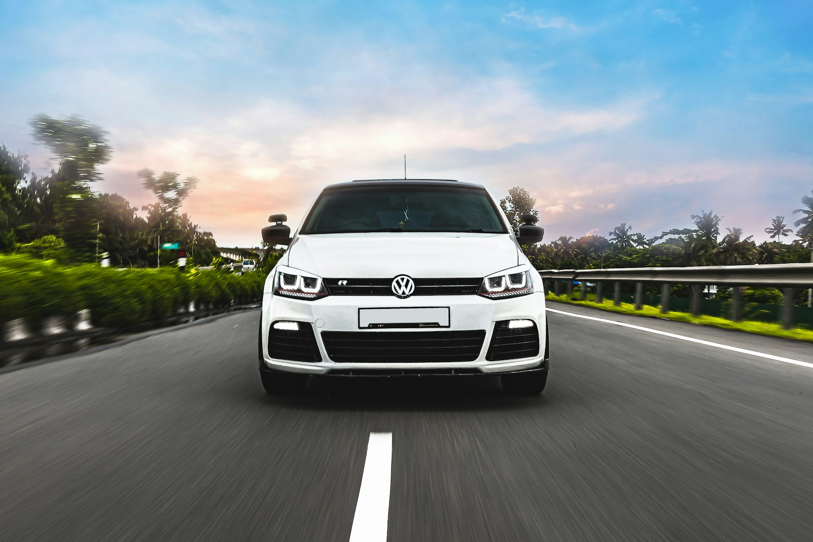 White Volkswagen car driving on the road during daytime – Representing the freedom and safety provided by AL-GA Insurance.